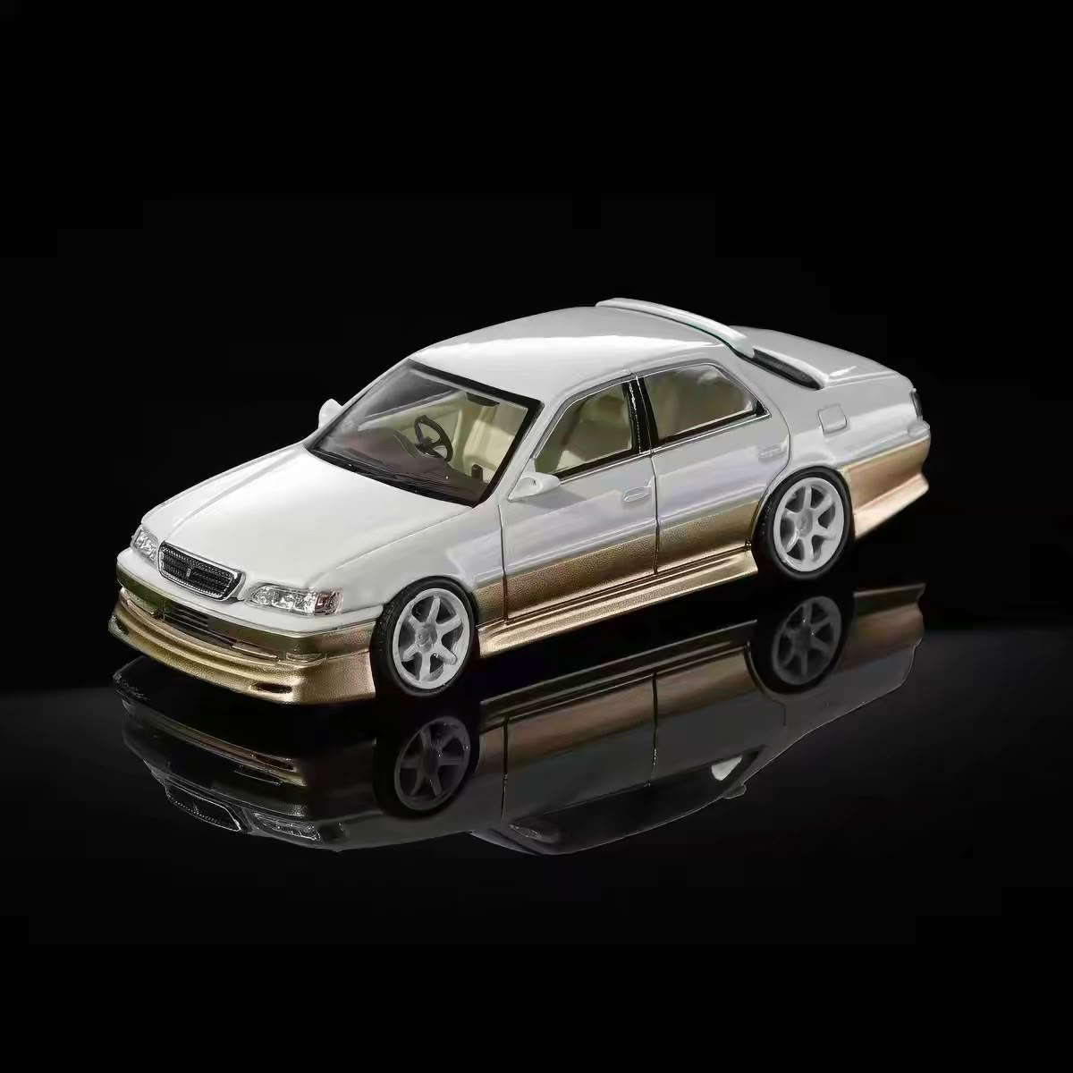 White and gold 1/64 Toyota JZX100 Cresta model car, front side view