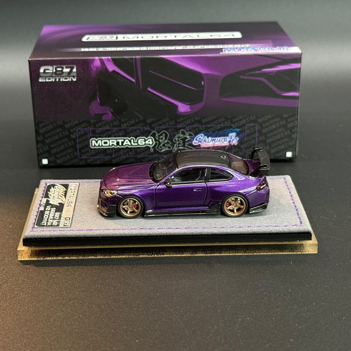Purple model car with gold wheels and open hood on display base
