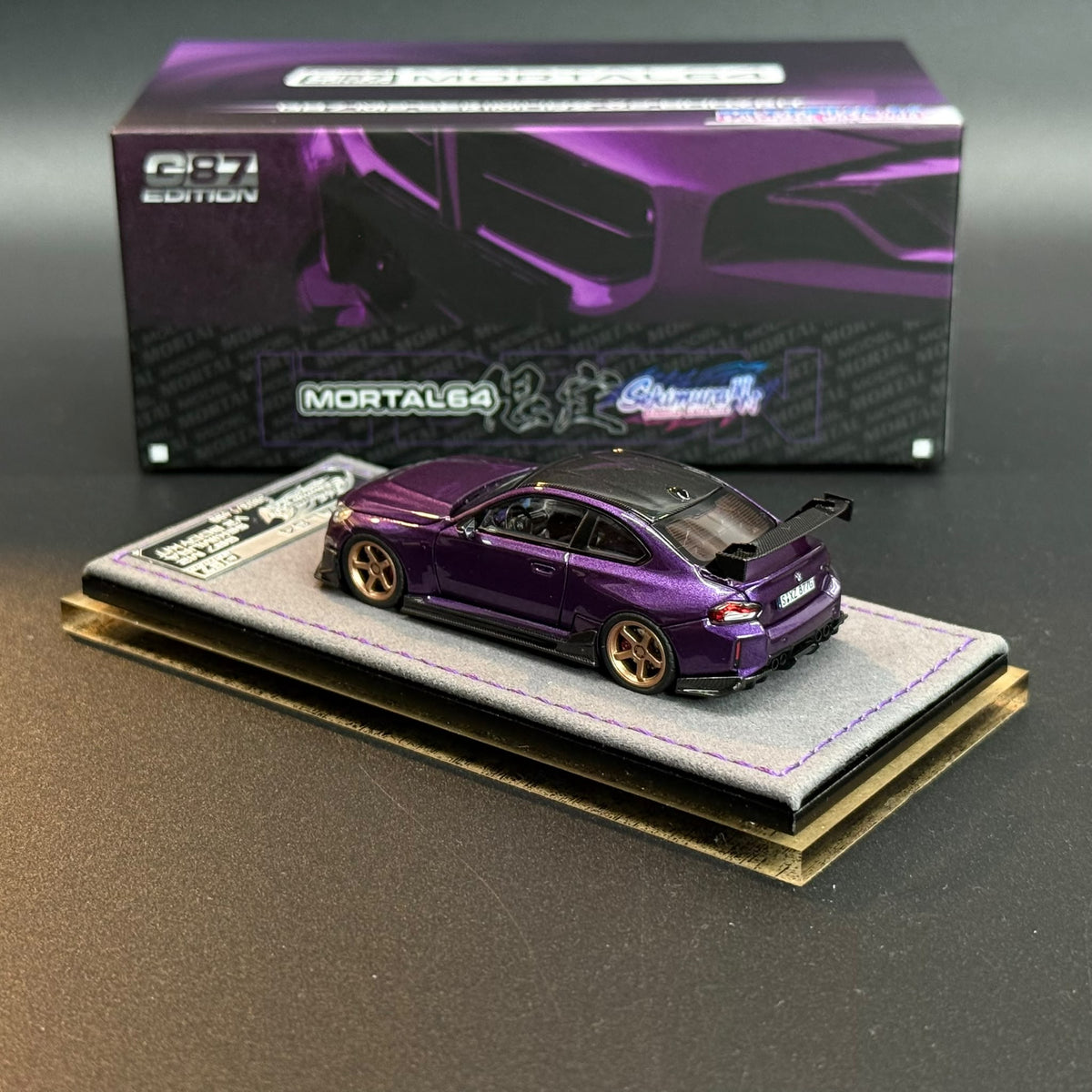 Purple model car with gold wheels, side view on display base