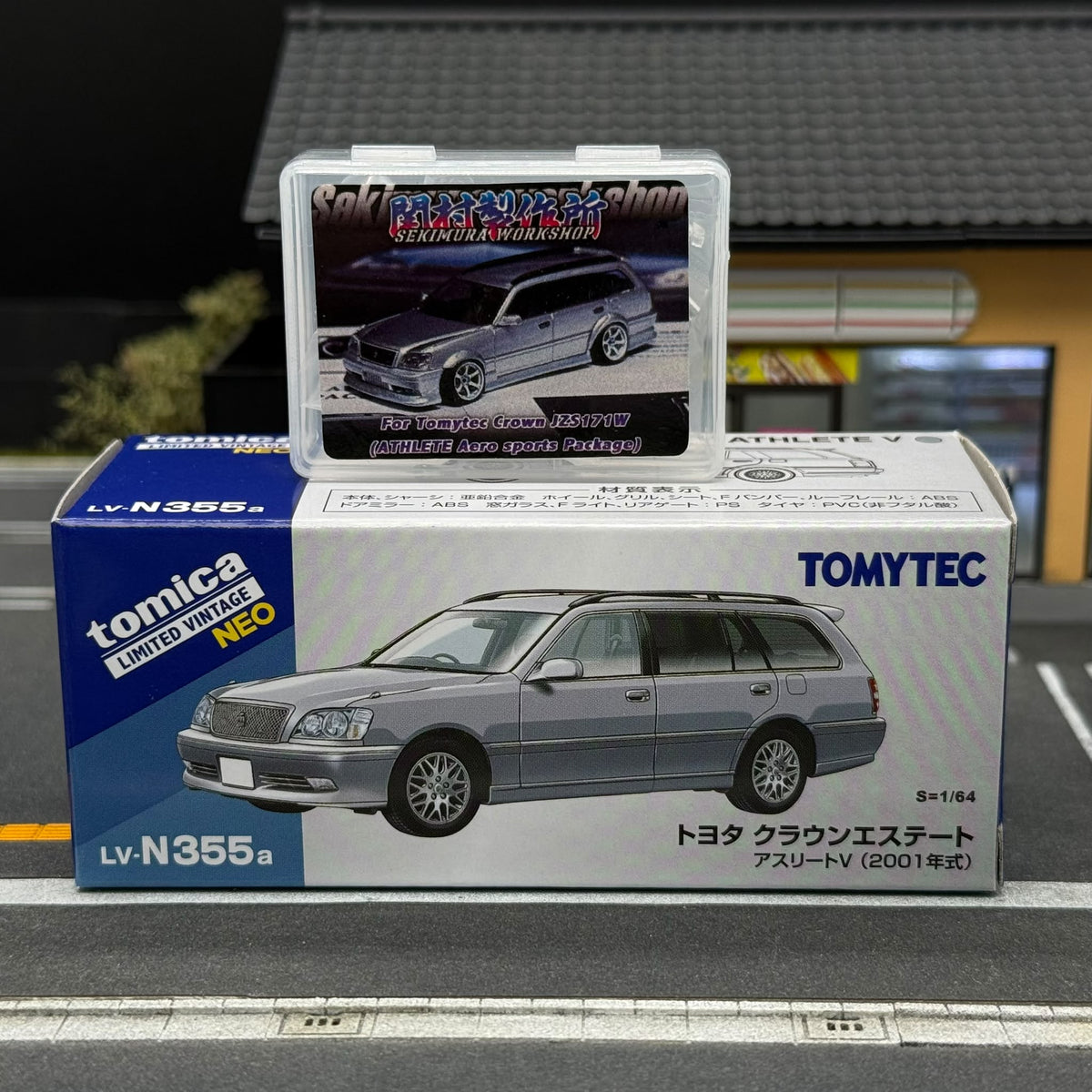 Silver Toyota Crown JZS171W wagon model with aero body kit, shown on its Tomytec box