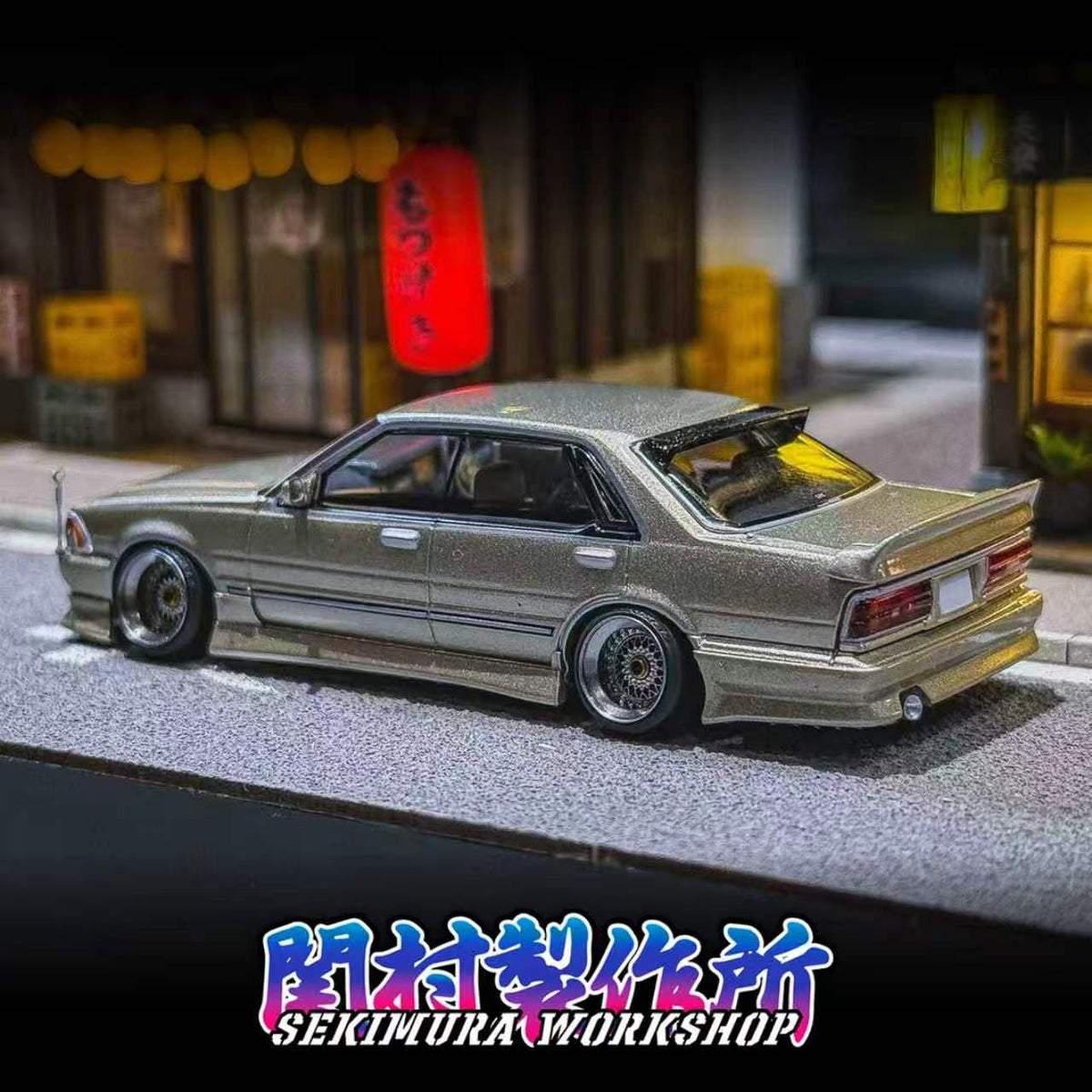 Rear three-quarter view of a silver Nissan Y31 Cedric model with Sekimura VIP bodykit